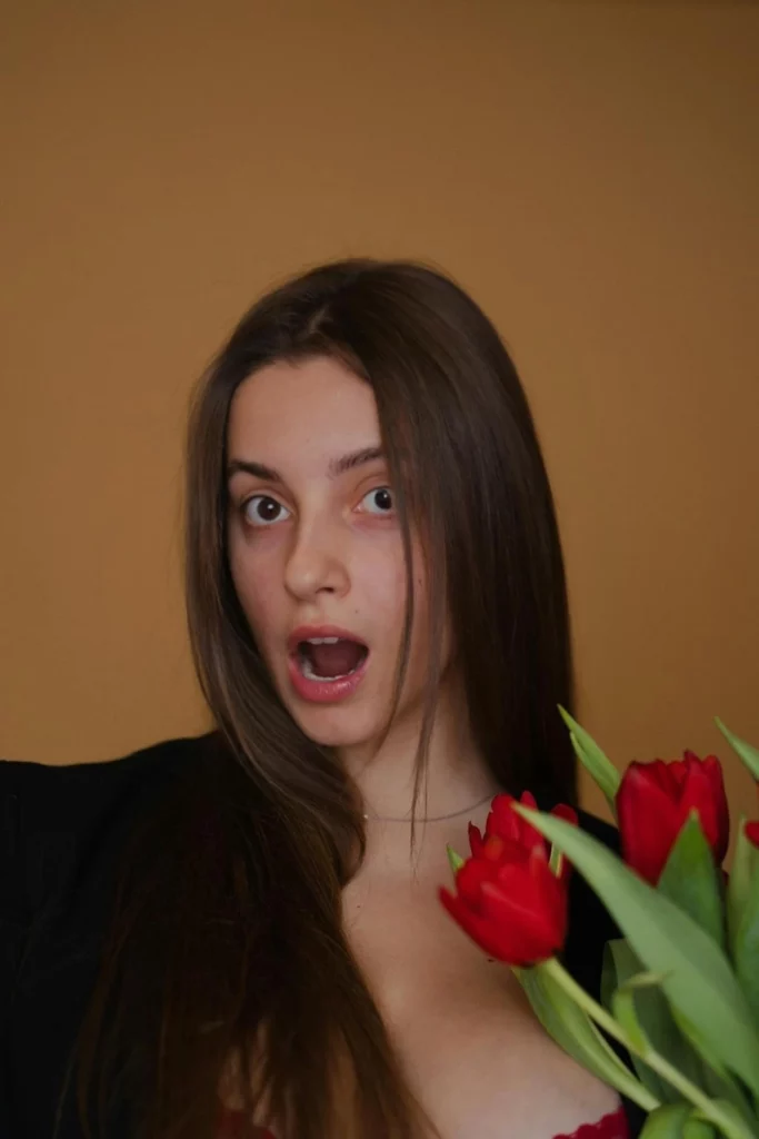 Astonished image of a young girl holding flowers