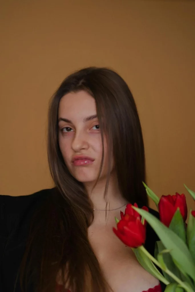 Disgusted image of a young girl holding flowers