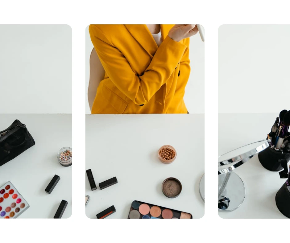 Eine Nahaufnahme eines weißen Tisches, auf dem ein Haufen Make-up liegt und auf dem eine Frau im gelben Anzug das Make-up aufträgt